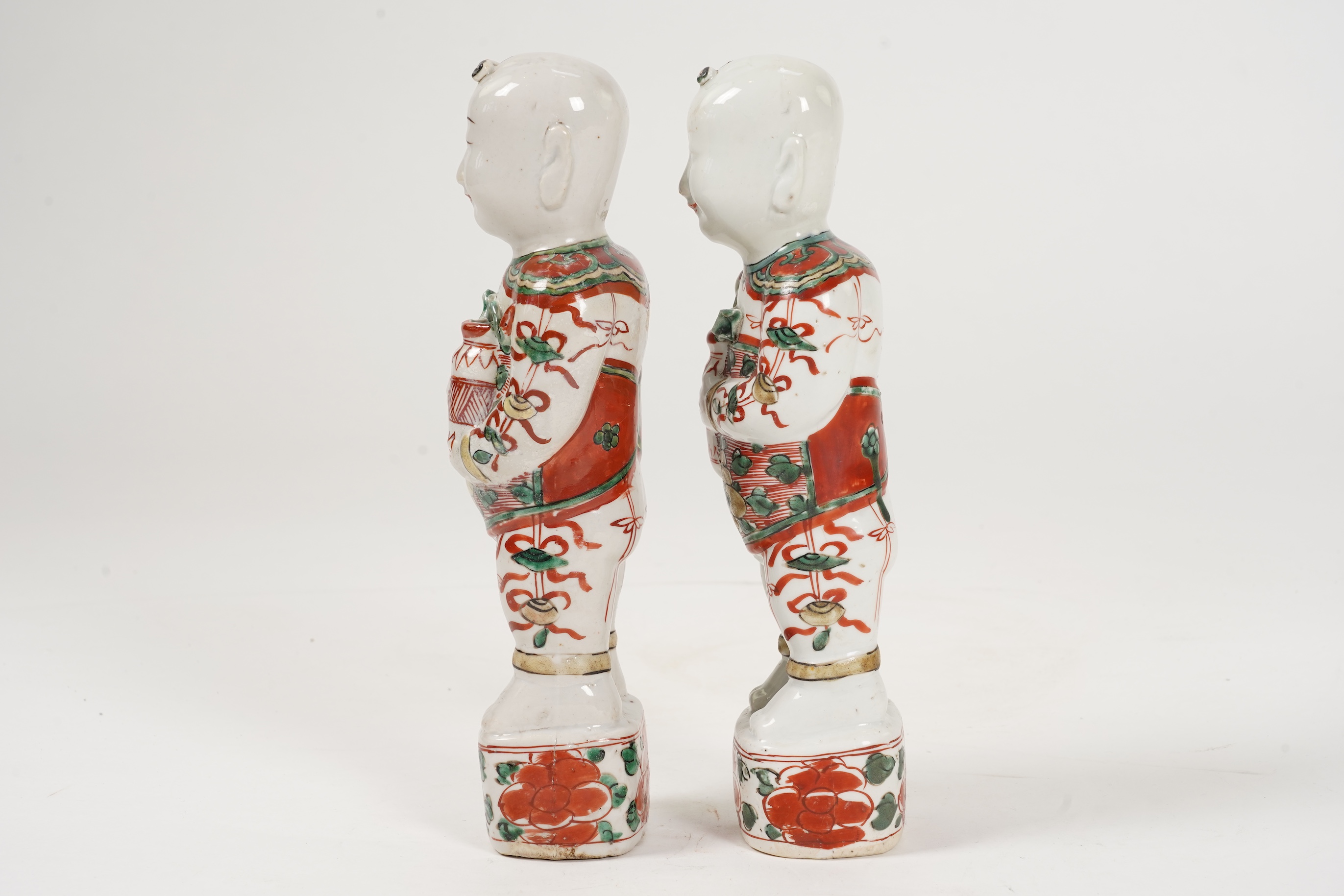 A pair of Chinese famille verte figures of smiling boys, Kangxi period
